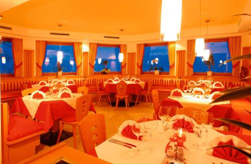 a dining room with tables and chairs and windows at Hotel Laurin in Tires