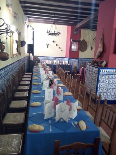 a row of tables in a room with blue table cloth at La Posada de Eustaquio in Canjáyar