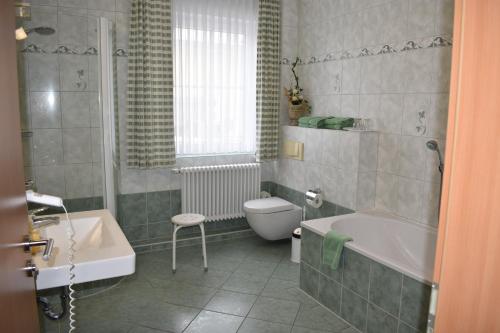 a bathroom with a tub and a toilet and a sink at Hotel garni "Am Hafen" in Havelberg