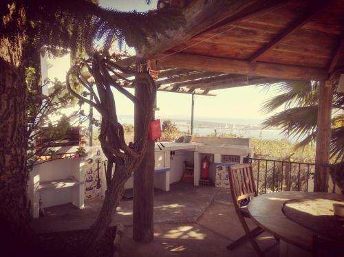eine Veranda eines Hauses mit einem Tisch und einem Baum in der Unterkunft Moinho do Marco in Setúbal