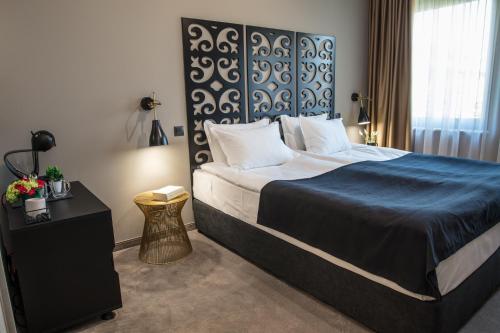 a bedroom with a large bed with a blue blanket at Reverence Boutique Hotel in Varna City