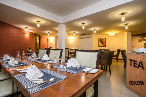 a restaurant with a long wooden table and chairs at Viyana Boutique Hotel in Kandy