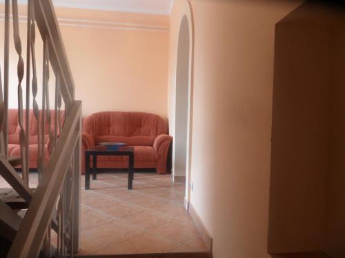 a hallway with a red couch and a table at Famvarga Apartmanház in Balatonfenyves