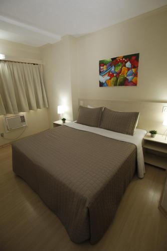 a bedroom with a large bed and a painting on the wall at klein Ville Esteio Br in Esteio