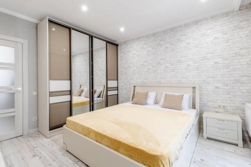 a bedroom with a large bed and a brick wall at InshiApartments on Hazova str 3 in Lviv