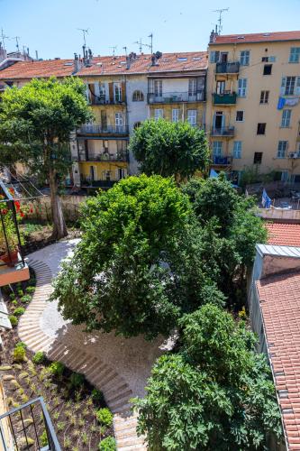 a view of a garden with trees and buildings at L'Abeille - Boutique Apartments in Nice