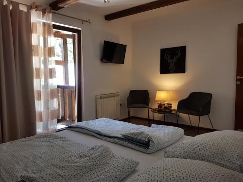 a bedroom with a bed and two chairs and a window at Sunshine Dreams Villa Jahorina in Jahorina