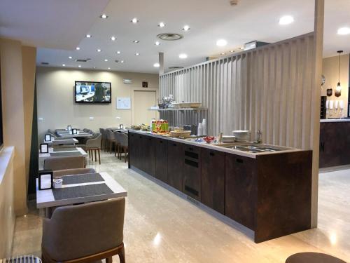 a restaurant with a counter and a dining room at Oasi Village Hotel in Milan