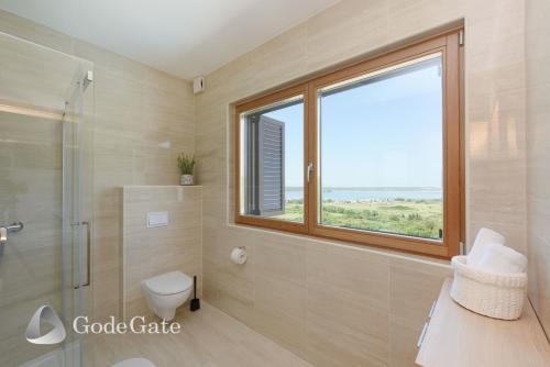 a bathroom with a shower and a toilet and a window at Villa Lubey in Ljubač