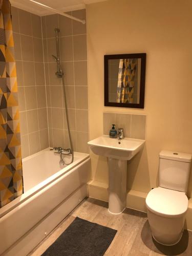 a bathroom with a sink and a toilet and a bath tub at Southampton Gem in Southampton