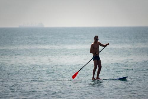a man standing on a paddle board in the ocean at Maison Dedine- SmallLuxuryHotels -Adults Only in Sidi Bou Saïd