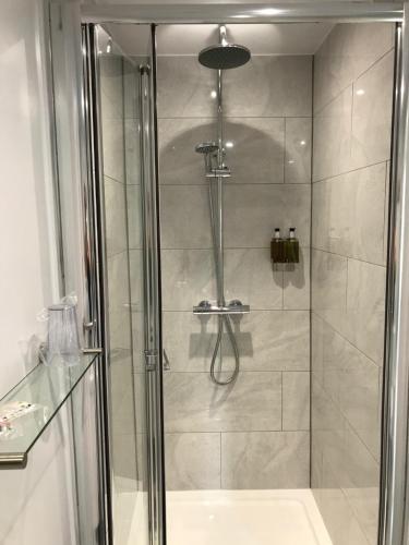 a bathroom with a shower with a glass door at Holden House in Shardlow