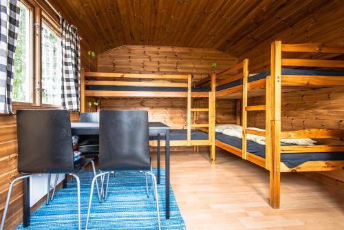 a room with two bunk beds and a table and chairs at Bromölla Camping o Vandrarhem in Bromölla