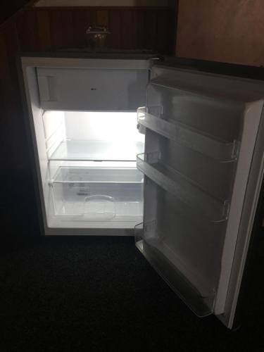 Un refrigerador vacío con la puerta abierta en una habitación. en Pension Milštejn, en Rousínov