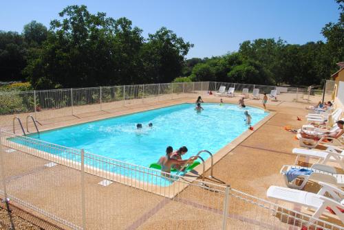 un groupe de personnes dans une piscine dans l'établissement MOBILHOME 3 CHAMBRES, à Veyrignac