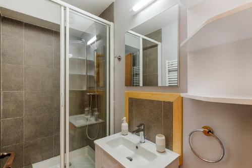 une salle de bain avec un lavabo et une douche dans l'établissement Residence Les Nereides - maeva Home, à Belle Plagne