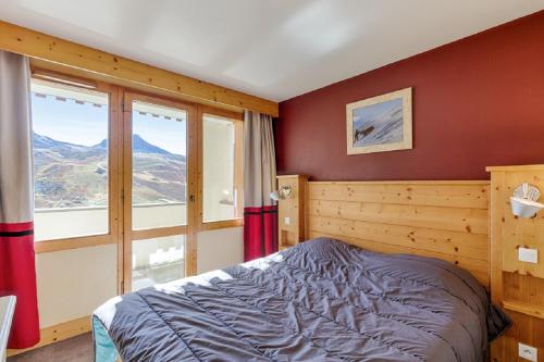 une chambre avec un lit et une grande fenêtre dans l'établissement Residence Les Nereides - maeva Home, à Belle Plagne