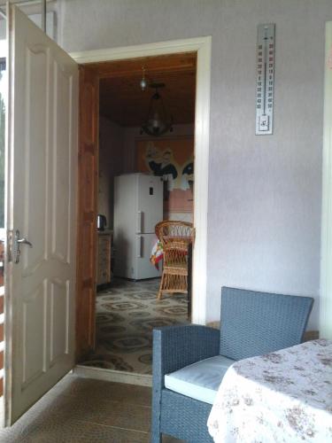 a kitchen with a door open to a room with a table at Hotel Коттедж Leleka Vyzhnynsia in Rivna