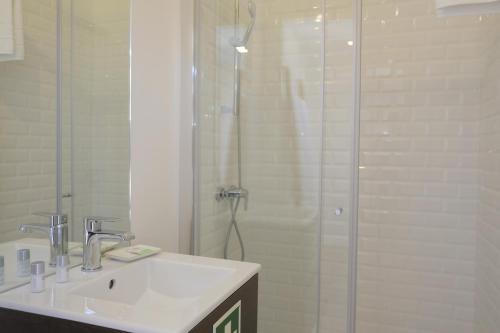 a bathroom with a sink and a glass shower at Oporto Wall Apartments in Porto
