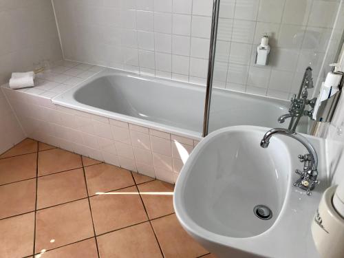 a bathroom with a white tub and a sink at Schloss Diedersdorf in Diedersdorf