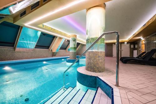 a swimming pool in a building with a swimming pool at Piramida Park Hotel & Wellness in Tychy