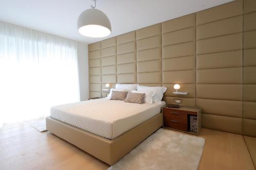 a bedroom with a bed and a large wall at Stylish apartment 100 m from the beach in Opatija