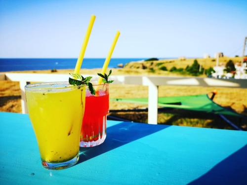 dos bebidas sentadas en una mesa cerca de la playa en Hotel Bavaria, en Sinemorets