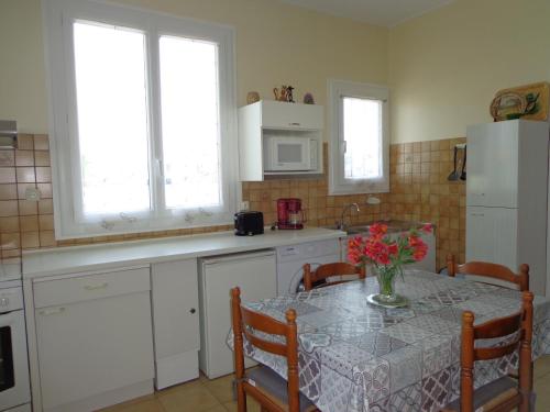 une cuisine avec une table avec un vase de fleurs dessus dans l'établissement appt T2 C Bougue, à Soustons