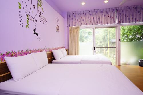Un dormitorio con dos camas y una ventana. en 蓬萊生態農場仙山民宿, en Nanzhuang