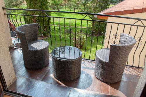 four chairs and a trash can on a balcony at Relais Vosgien - Hôtel Restaurant "la Table de Sophia" in Saint-Pierremont
