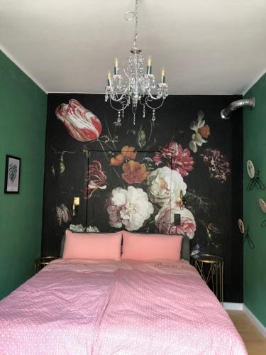 a bedroom with a pink bed with a floral wallpaper at Luna Estela in Bayreuth