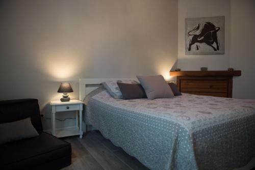 een slaapkamer met een bed, een stoel en een lamp bij L'effet mer in Arles