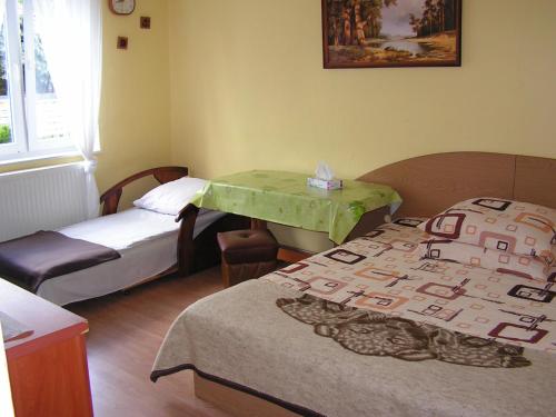 シフィノウイシチェにあるPokoje u Aniのベッド2台とテーブルが備わる小さな客室です。