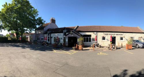 een gebouw met een auto geparkeerd op een parkeerplaats bij The Half Moon Inn in Ashington