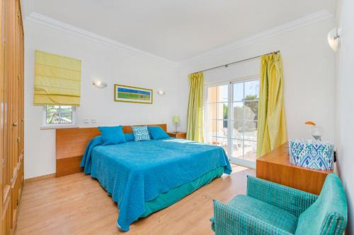 una camera con un letto blu e due sedie di Villa Dia a Vale do Lobo