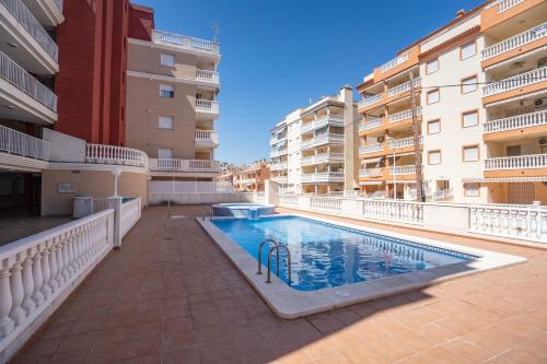 a swimming pool in an apartment complex with buildings at Ideally Located Holiday Apartment in Moncófar