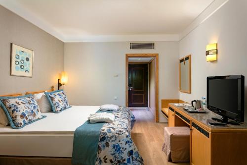ベレキにあるXanadu Resort - High Class All Inclusiveのベッド1台、薄型テレビが備わるホテルルームです。
