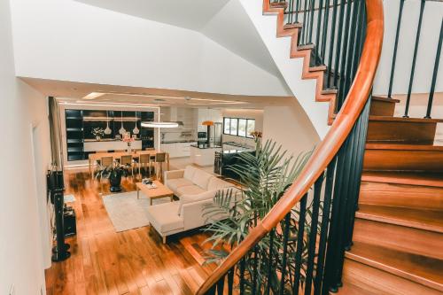a living room and dining room with a staircase at HNC Premier Hotel & Residences in Hanoi
