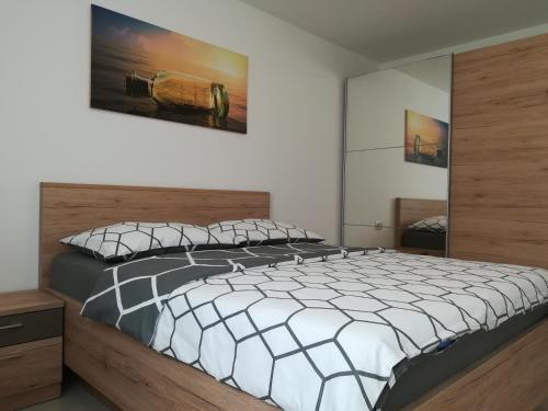 a bedroom with a large bed with a wooden headboard at Apartman Ana in Porat