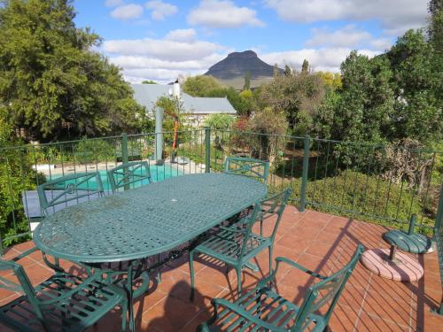 a patio with a table and chairs and a pool at 4 Rothman Street B&B in Graaff-Reinet