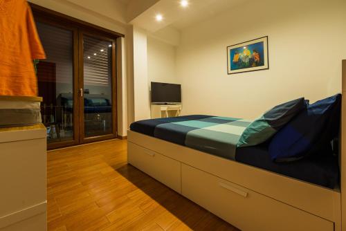una camera con un grande letto e una televisione di L'Approdo B&B a Gaeta