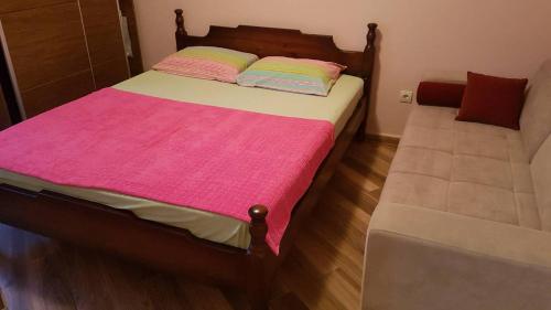 a bedroom with a bed with a pink blanket at Apartman Jasovic in Risan