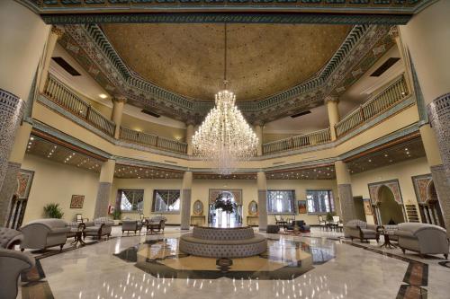 a large lobby with a fountain and a chandelier at Grand Mogador Agdal in Marrakesh