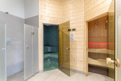 a shower with a glass door in a bathroom at Zefiro Chmielna in Gdańsk