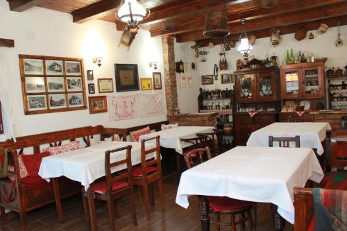 a restaurant with white tables and chairs in a room at Zsuzsanna Paraszthaz in Praid