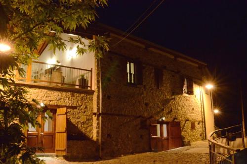 a stone building with a balcony at night at To Kastri in Kalopanayiotis