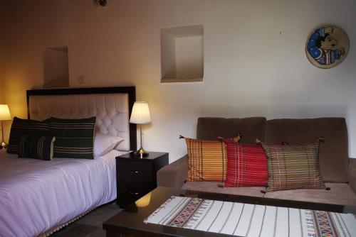 a bedroom with a bed and a couch with colorful pillows at To Kastri in Kalopanayiotis