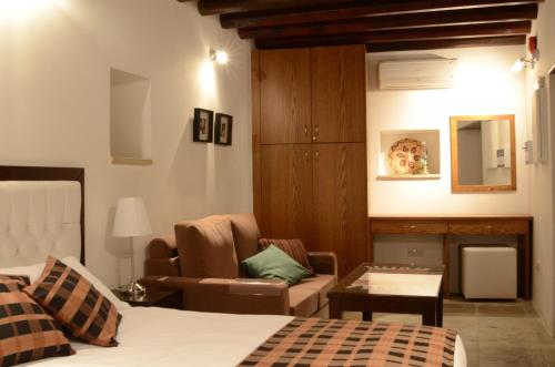 a bedroom with a bed and a couch and a chair at To Kastri in Kalopanayiotis