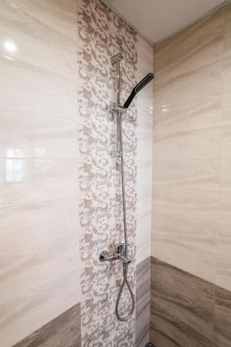 a shower in a bathroom with a stone wall at Toni's Guest House in Melnik