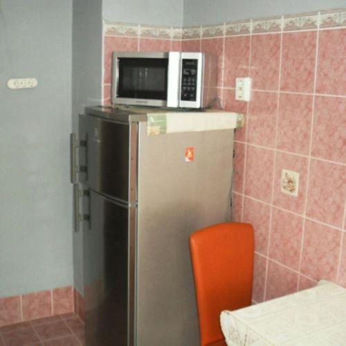 a microwave on top of a refrigerator in a kitchen at Fészek Apartman in Békéscsaba